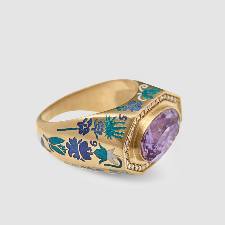 Gold ring with purple gemstone and floral engravings on a light gray background